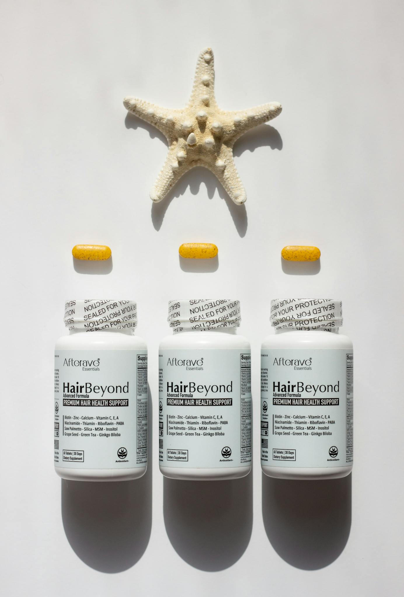 HairBeyond vitamin bottles arranged elegantly with a starfish backdrop.